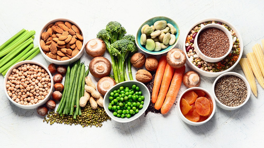 Image of bounty of fresh superfoods and vegetables and seeds on a white background